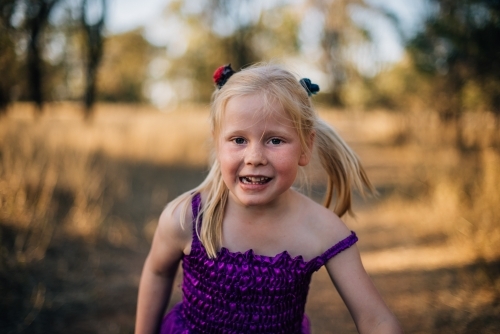 Happy young girl playing outside - Australian Stock Image