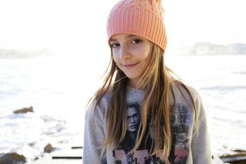 Happy young girl standing by the ocean - Australian Stock Image