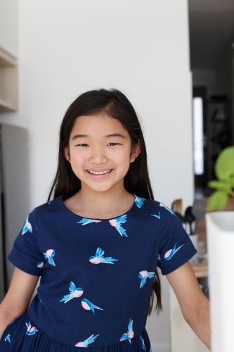 Happy young Japanese girl in kitchen - Australian Stock Image