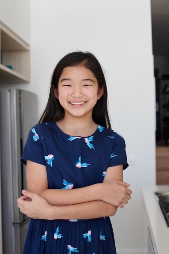 Happy young Japanese girl in kitchen