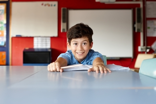 Happy young school boy in classroom - Australian Stock Image