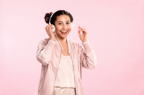 Happy young woman, listening to music on headphones & dancing. - Australian Stock Image