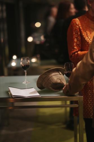 Hat sitting on table with glasses of red wine - Australian Stock Image