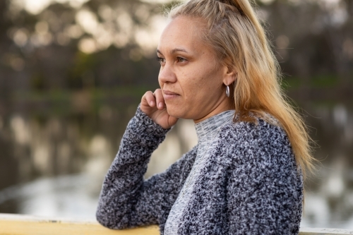 head and shoulders of aboriginal woman with blonde hair side on to camera