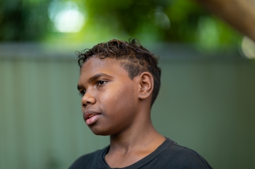 head and shoulders of tween boy outside looking away - Australian Stock Image