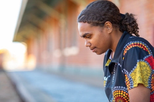 head and shoulders of young aboriginal woman with hair tied back - Australian Stock Image
