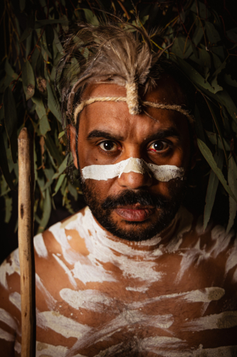 Headshot of aboriginal male with face paint staring intently - Australian Stock Image
