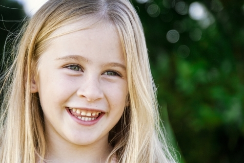 Headshot of six year old smiling looking away