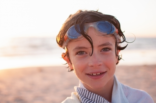 Headshot of young boy on beach after swimming