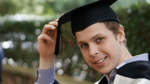 Headshot of young male graduating with cap - Australian Stock Image