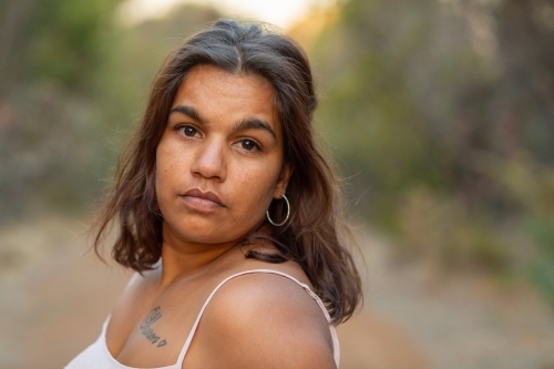 Headshot of young woman with wavy, brown hair with a blurry background - Australian Stock Image