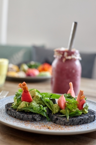 Healthy avocado on toast and smoothie ready to eat - Australian Stock Image