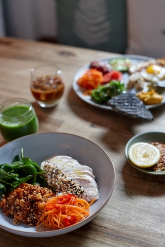 Healthy chicken and salad dish on wooden table in cafe - Australian Stock Image