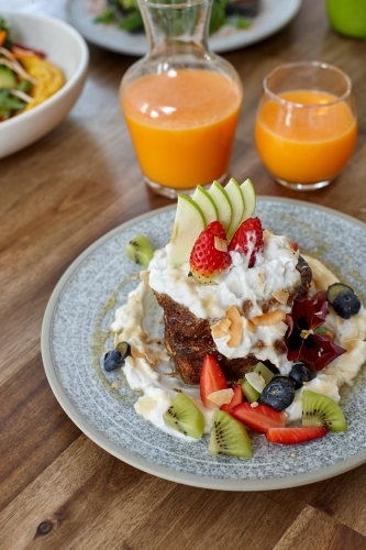 Healthy organic vegan food and drinks on wooden table - Australian Stock Image