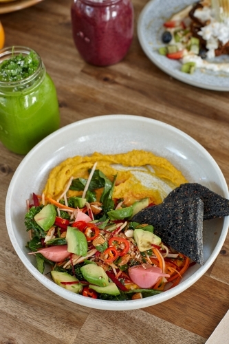 Healthy organic vegan food and drinks on wooden table - Australian Stock Image