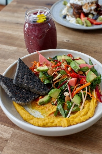 Healthy organic vegan food and drinks on wooden table - Australian Stock Image