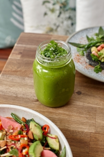 Healthy organic vegan food and drinks on wooden table - Australian Stock Image