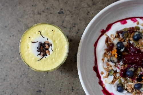 Healthy porridge served with hot beverage in vegetarian cafe - Australian Stock Image