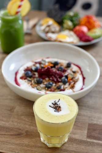 Healthy porridge served with hot beverage in vegetarian cafe - Australian Stock Image
