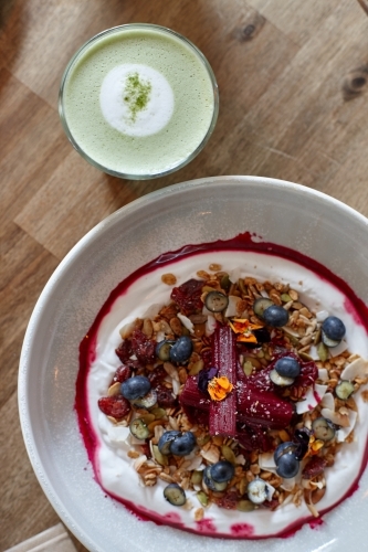Healthy porridge served with hot beverage in vegetarian cafe - Australian Stock Image