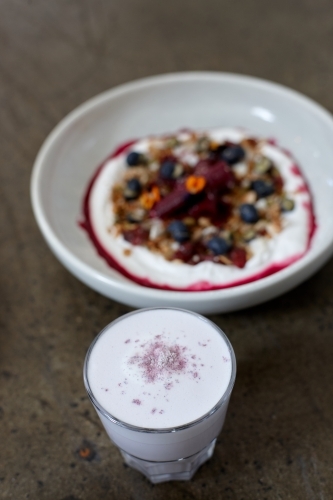 Healthy porridge served with hot beverage in vegetarian cafe - Australian Stock Image