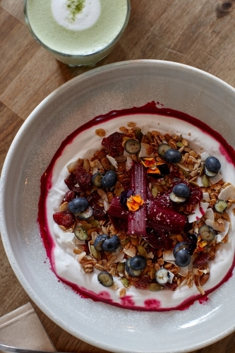 Healthy porridge served with hot beverage in vegetarian cafe - Australian Stock Image