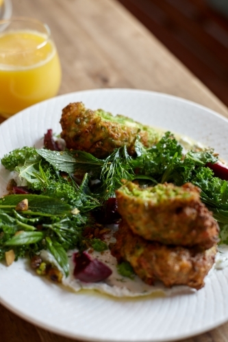 Healthy vegetarian falafel and salad dish on wooden table - Australian Stock Image