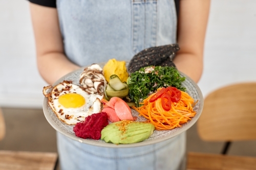 Healthy vegetarian meal being served by waiter - Australian Stock Image
