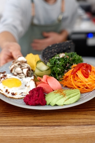 Healthy vegetarian meal being served on table - Australian Stock Image