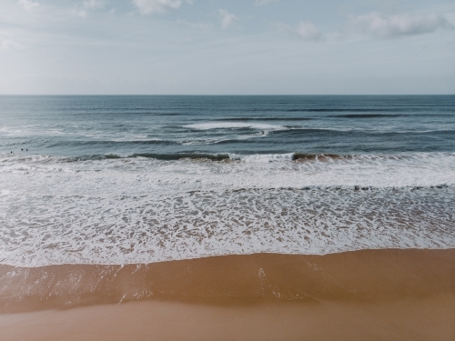 High angle shot of waves crashing on a deserted beach - Australian Stock Image