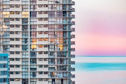 High rise seaside apartment building with pink sunset over the beach on the Gold Coast - Australian Stock Image