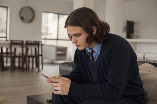 High school student using smart phone at home