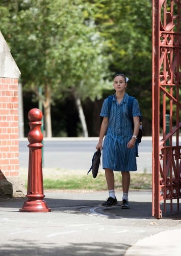 high school student walking through school gates - Australian Stock Image