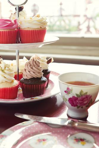High tea with cupcake stand and cup of tea in vintage crockery