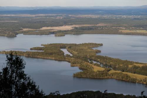 High view of river reach flowing into lake on a sunny day - Australian Stock Image