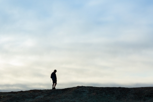 Hiker in distance silhouetted against sky - Australian Stock Image
