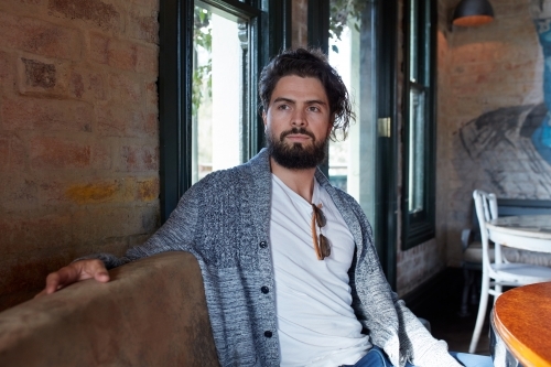 Hipster man enjoying drinking a beer at pub - Australian Stock Image