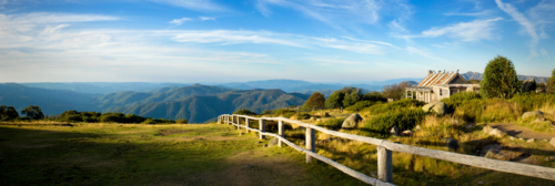 Historic mountain hut overlooking endless blue ranges. - Australian Stock Image