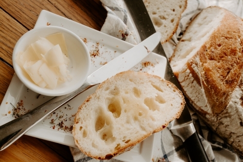 Home made Sour dough bread cooling on a tea towel which is on a wooden chopping platter board - Australian Stock Image