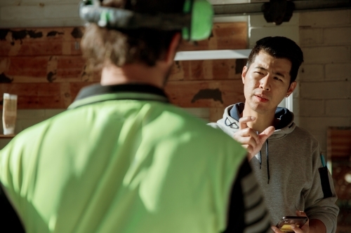 Home owner discussing plans with a tradie builder - Australian Stock Image