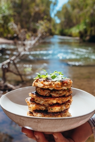 Homemade zucchini fritters next to the river when camping - Australian Stock Image