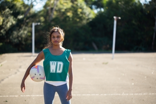 horizontal outdoor shot of a Indian woman in sports wear holding a ball