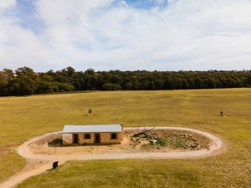 horizontal shot of a barn with a path around it and with trees in the background - Australian Stock Image