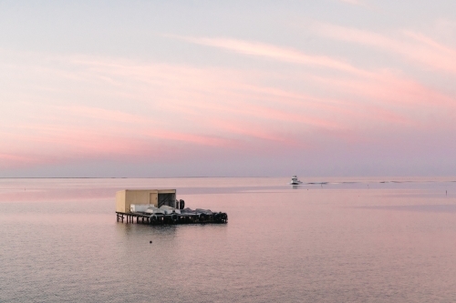 Horizontal shot of a crayfishing boat at sunrise with shack