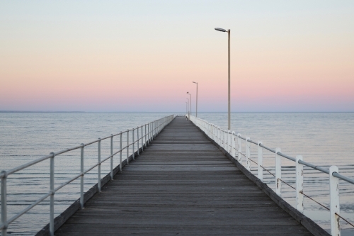 Looking out along a jetty at sunset - Australian Stock Image