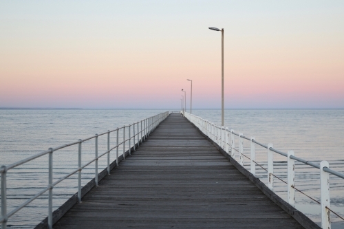 Looking out along a jetty at sunset