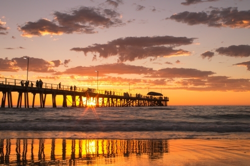 Horizontal shot of a long wharf on the beach at sunset - Australian Stock Image