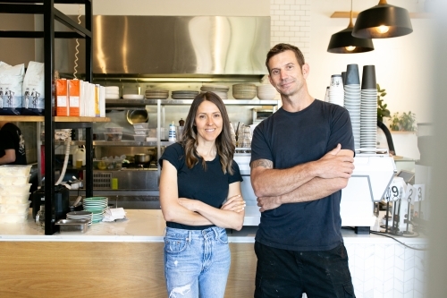 horizontal shot of a man and a woman both with arms crossed on chest  and wearing black shirt - Australian Stock Image