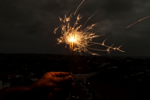 Horizontal shot of a sparkler with a dark background - Australian Stock Image