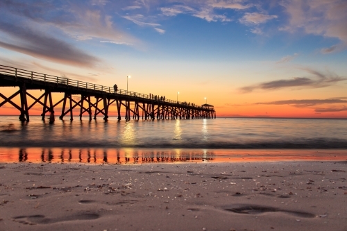 Horizontal shot of a wharf on the beach at sunset - Australian Stock Image